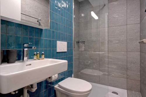 Un baño con lavabo, inodoro y ducha. en BANK House Studio M 405 - GRIWA RENT, en Interlaken