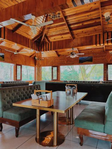 a dining room with a table and a couch at Appas Hotel in Bīr