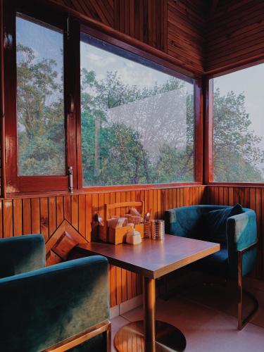 a room with a table and two chairs and a window at Appas Hotel in Bīr
