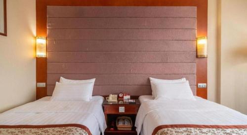 a hotel room with two beds and a headboard at Quanzhou Hotel in Quanzhou
