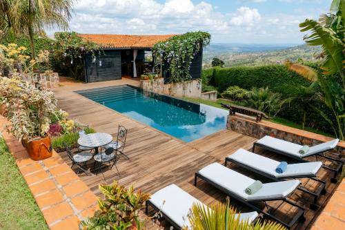 a backyard with a pool with chairs and a table at Villa Kigali in Kigali