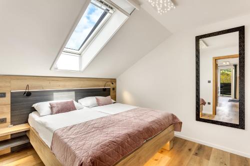 a bedroom with a large bed and a mirror at Apartmaji Kunej pod Gradom in Podsreda