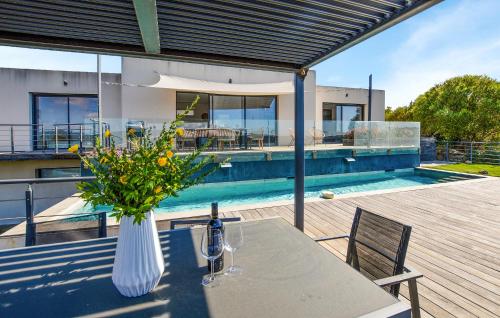 un vase de fleurs sur une table à côté d'une piscine dans l'établissement Villa Spacieuse Proche Plages, à Vardiola