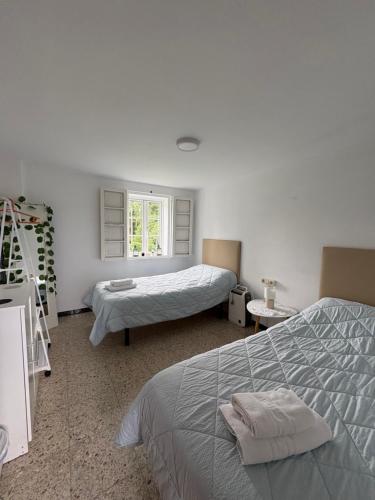 a bedroom with two beds and a window at A casa do Rio - The River House in Arzúa