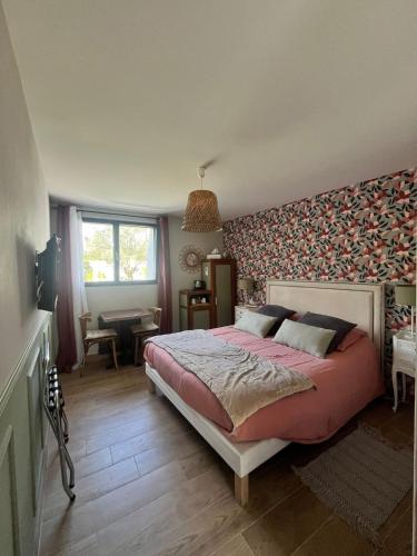 - une chambre avec un grand lit et un mur recouvert de papier peint dans l'établissement Au gré des vents, à Saint-Quay-Portrieux