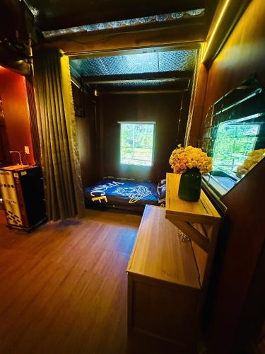 a room with a bed and a table with flowers on it at Đông Giang Sky Villa in A Sơ Ră Amo