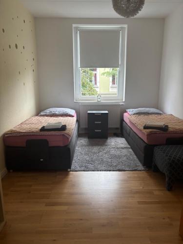 two beds in a room with a window at Mitten im Ruhrgebiet immer Willkommen, wlan , Netflix, Parking Free, 100m2 flat in Oberhausen