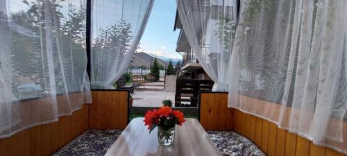 a vase of flowers sitting on a table in a window at 12 Месяцев in Cholpon-Ata