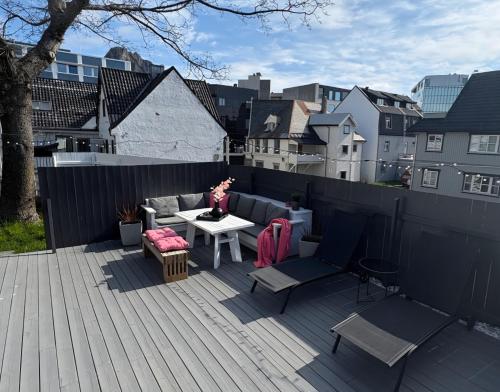 a woman is sitting on a patio on a roof at Flott beliggenhet svært sentralt i sentrum in Svolvær