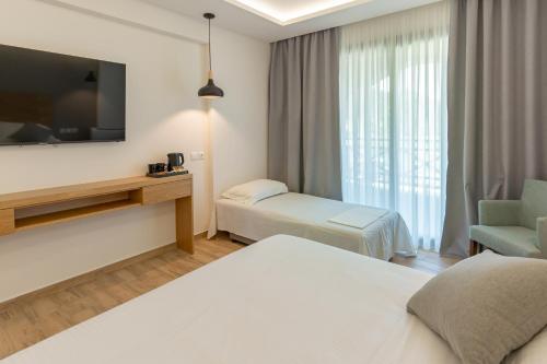 a hotel room with two beds and a flat screen tv at Archontiko Liamas in Stavros