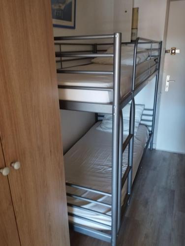 Cette chambre dispose de lits superposés et d'une porte en bois. dans l'établissement Le Paradis c'est ici, à Six-Fours-les-Plages