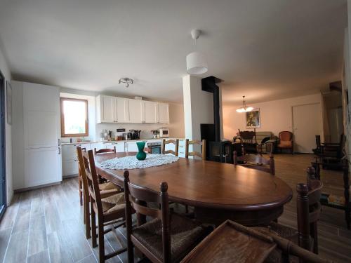 una sala da pranzo e una cucina con tavolo e sedie di Gîte La Vacale- 2 à 10 personnes a Capendac