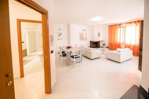 a living room with white furniture and a table at Casa Belvedere in Le Castella