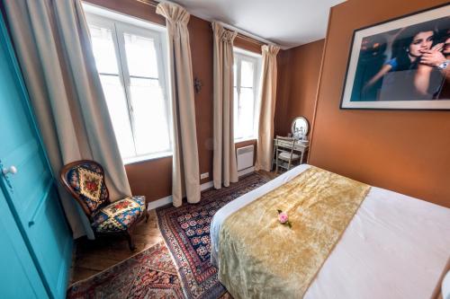 a bedroom with a bed and two windows at Centre historique de LYONS LA FORET Hotel de Maître le Cottage in Lyons-la-Forêt