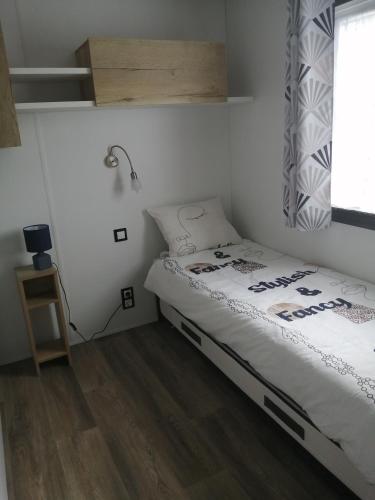 une petite chambre avec un lit et une fenêtre dans l'établissement Mobil home Menanteau, aux Mathes