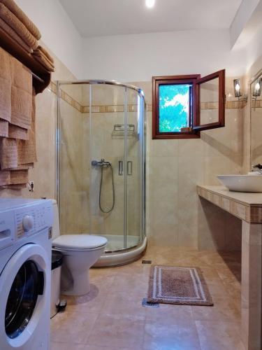 a bathroom with a shower and a washing machine at Villa villaeri in Skiathos