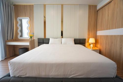 a large white bed in a room with a window at FLAMINGO Ibiza HaiTien - Ivy Abtel in Thanh Hóa