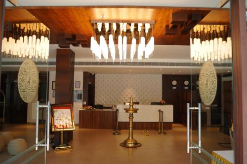 a lobby with chandeliers and a altar in a building at Saugandhika West Gate in Wayanad