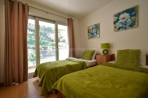 a bedroom with two green beds and a window at Kotorscapes in Muo
