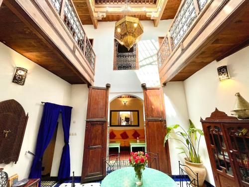 a room with a table with a vase of flowers on it at Charming Riad Medina View 4 AC Bedrooms Panoramic Terrace Central Fez in Fès al Bali