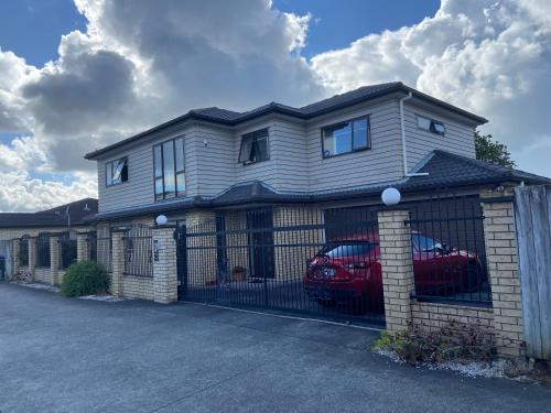 a house with a fence and two cars in it at Self Contained Room in Hillsborough in Auckland