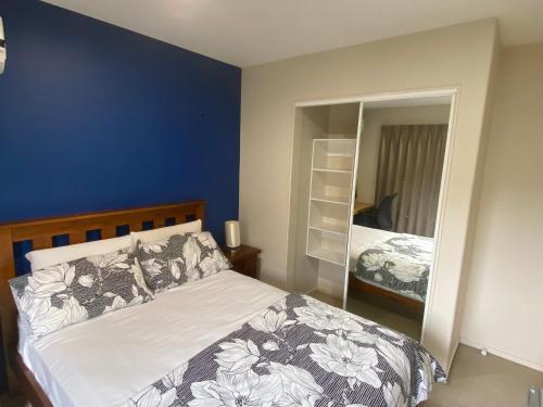 a bedroom with a large bed and a mirror at Self Contained Room in Hillsborough in Auckland