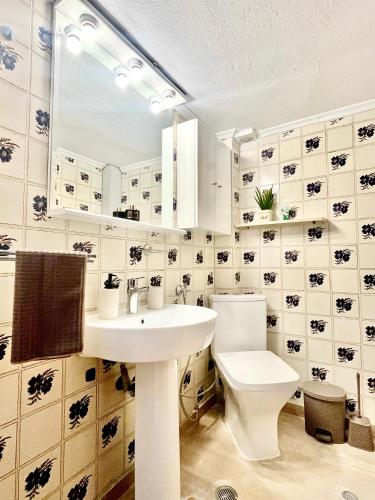 a bathroom with a white toilet and a sink at Thess City House with Parking in Thessaloniki