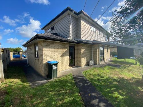 a small house with a blue trash can in a yard at Self Contained Room in Hillsborough in Auckland