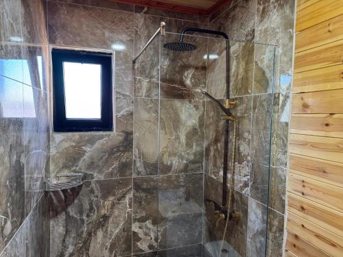 una doccia con una porta in vetro in un bagno di The Pool Pushi Park a Ksamil