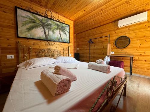 una camera da letto con un letto con asciugamani sopra di The Pool Pushi Park a Ksamil