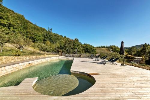 une piscine avec des chaises et un parasol dans l'établissement Jolie maison en plein coeur des bois et lavande pour 5 personnes, à Teyssières