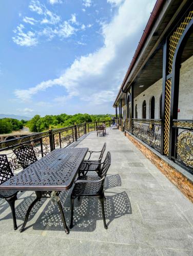 a patio with a table and benches on a building at Hotel Leoni in Kʼveda Sakʼara