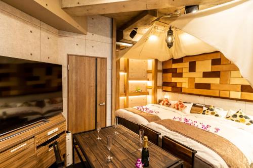 a bedroom with a large bed and a wooden table at Hotel Bali An Resort Shinjuku Forest in Tokyo