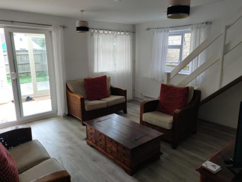 a living room with two chairs and a coffee table at Home in Kington St Michael in Kington St Michael