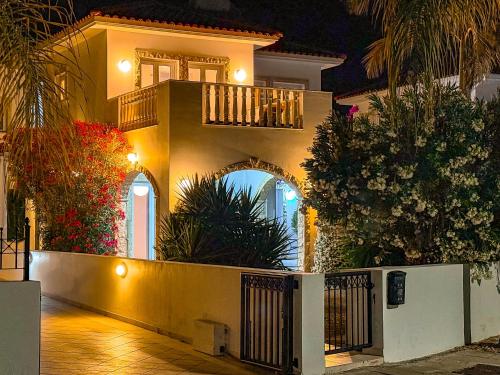 a yellow house with a balcony and plants at Sunny Villa with Hot Tub, Garden and 2 Bedrooms, 5 Minutes to the Beach in Pyla