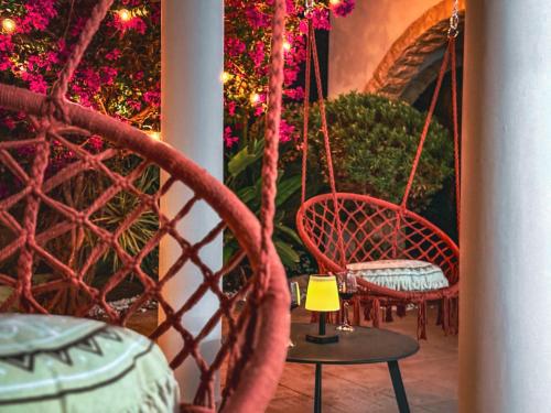 a porch with two chairs and a table with a lamp at Sunny Villa with Hot Tub, Garden and 2 Bedrooms, 5 Minutes to the Beach in Pyla