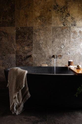 a bathroom with a black tub with a towel on it at The Stables in St Helens