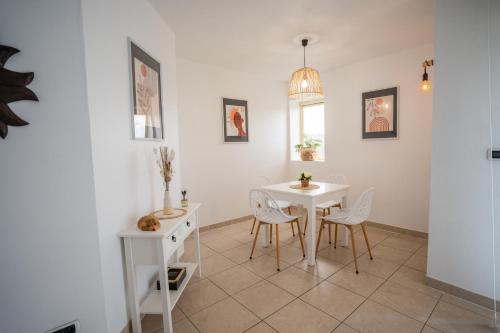 une salle à manger avec une table et des chaises blanches dans l'établissement La Felicità, à Albi
