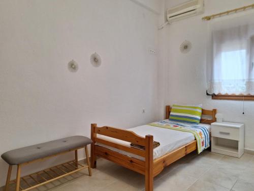 a bedroom with a bed and a bench in it at Sunny House in Pyrgadikia
