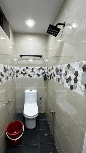 a bathroom with a toilet and a red trash can at Luna De Haus Homestay in Sungai Petani