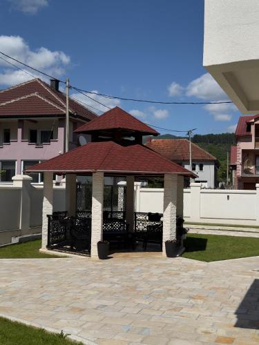 a gazebo with a red roof in a yard at Plav Serviced Apartments by Doni in Plav