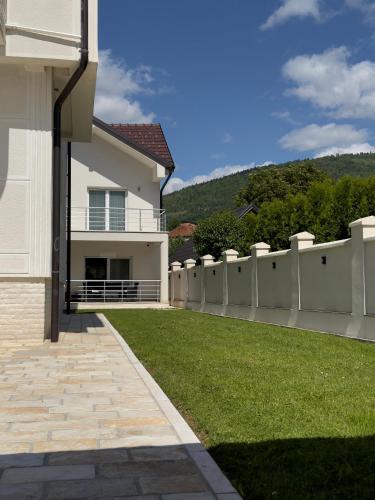 a white fence in front of a house at Plav Serviced Apartments by Doni in Plav