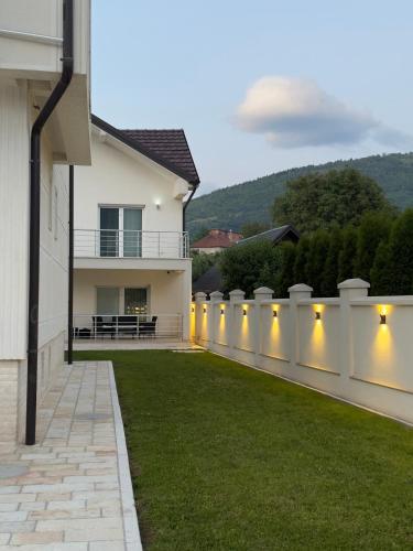 a fence with lights on the side of a house at Plav Serviced Apartments by Doni in Plav