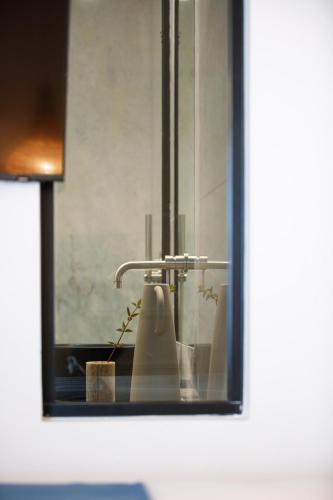 a bathroom mirror with a sink and a toothbrush at Sea Path III Chania city Center luxury Suites in Chania