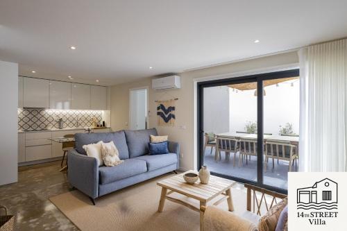 a living room with a blue couch and a kitchen at 14th Street Villa - Espinho in Espinho
