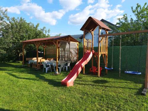 een speeltuin met een glijbaan en een speelhuis bij Villa NEA Ilidza in Sarajevo