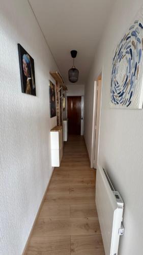 un couloir d'une maison avec deux photos sur le mur dans l'établissement Appartement Marina FACE MER, à Saint-Jean-de-Monts