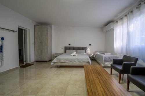 a bedroom with a bed and a couch and a table at אדום 179, דירות נופש in Eilat