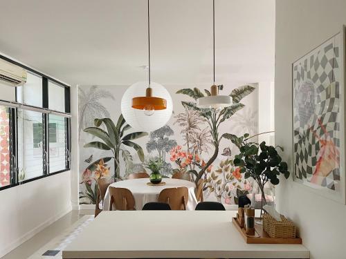 een eetkamer met een witte tafel en een plantenwand bij Casa Palm Spring in Bangkok