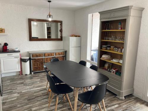 une cuisine avec une table, des chaises et un réfrigérateur dans l'établissement Camelia, à Saint-Jean-de-Monts